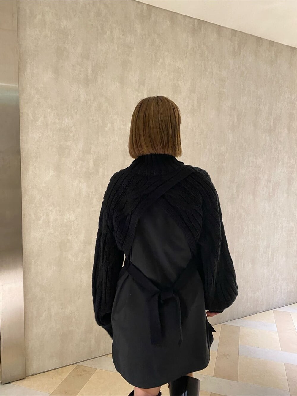 ブラック系のワンピース、ブラック系のブーツ、グレー系のハットを着用したレディースの秋コーディネートの5枚目の写真