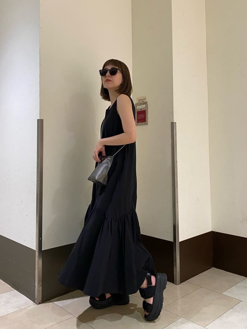 ホワイト系のサンダル、ブラック系のショルダーバッグ、ブラック系のワンピースを着用したレディースの夏コーディネートの2枚目の写真