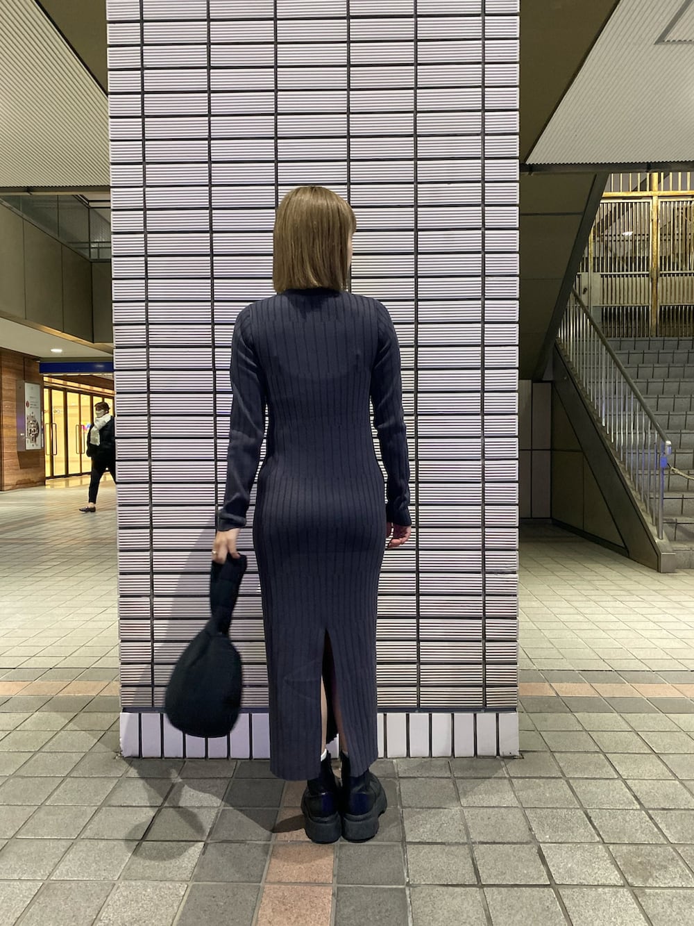 グレー系のワンピース、ブラック系のブーツを着用したレディースの冬コーディネートの3枚目の写真
