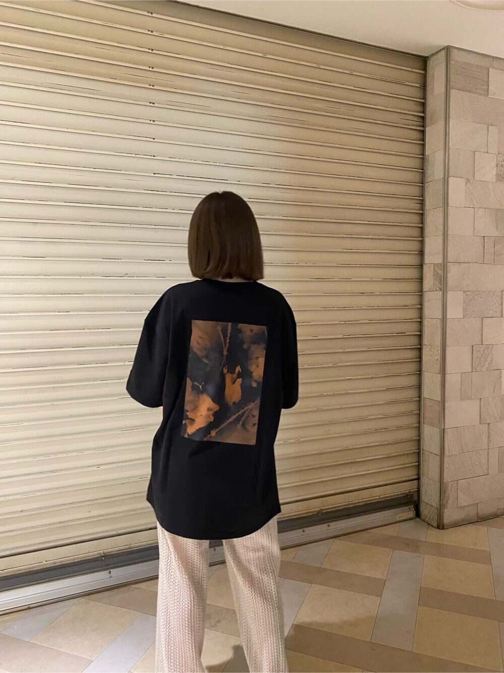 ブラック系のサンダル、ブラック系のTシャツ/カットソー、ホワイト系のスウェットパンツを着用したレディースの春コーディネートの3枚目の写真