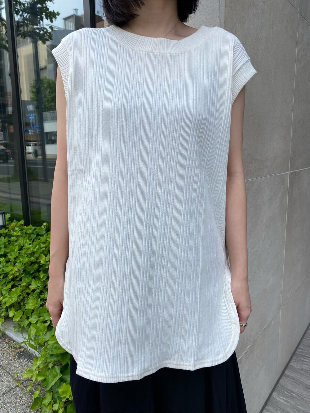 ブラック系のスカート、ブラック系のサンダル、ホワイト系のTシャツ/カットソーを着用したレディースの夏コーディネートの6枚目の写真