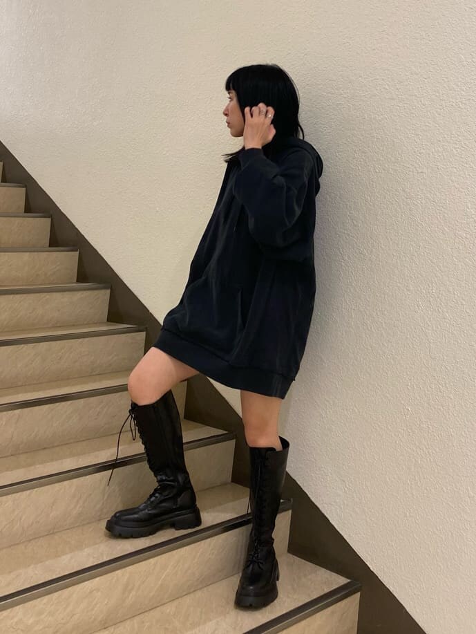 ブラック系のその他パンツ、グレー系のデニムジャケット、ブラック系のパーカーを着用したレディースの春コーディネートの2枚目の写真