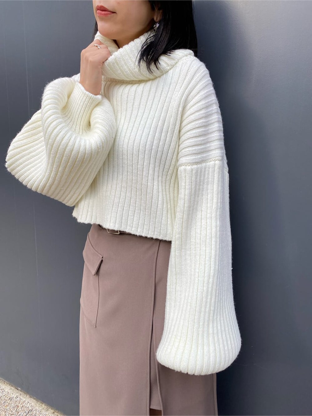 ベージュ系のスカート、ホワイト系のブルゾン、ブラウン系のブーツを着用したレディースの冬コーディネートの7枚目の写真