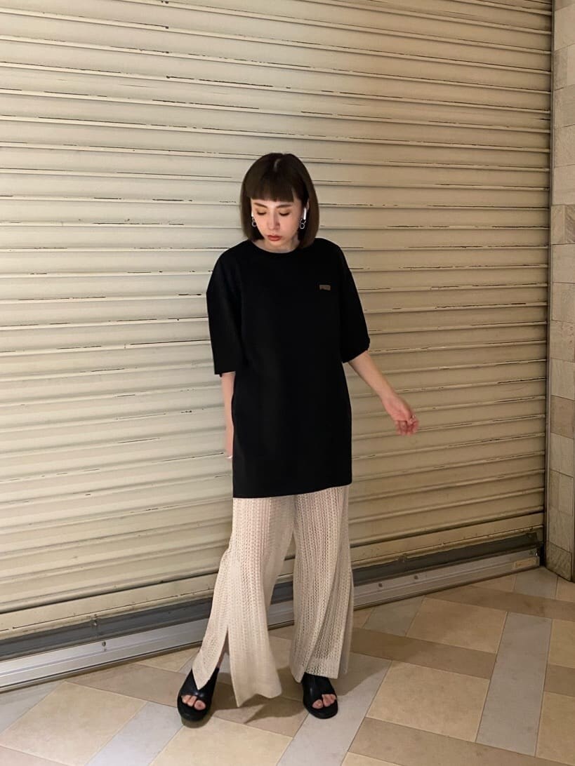 ブラック系のサンダル、ブラック系のTシャツ/カットソー、ホワイト系のスウェットパンツを着用したレディースの春コーディネートの2枚目の写真