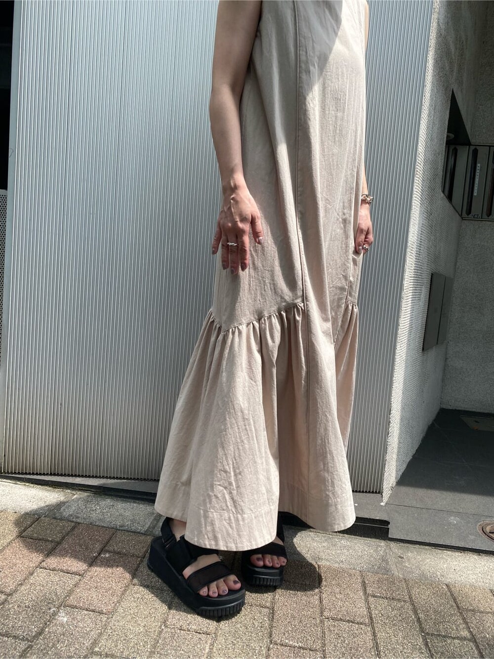 ベージュ系のワンピース、ブラック系のハットを着用したレディースの夏コーディネートの5枚目の写真