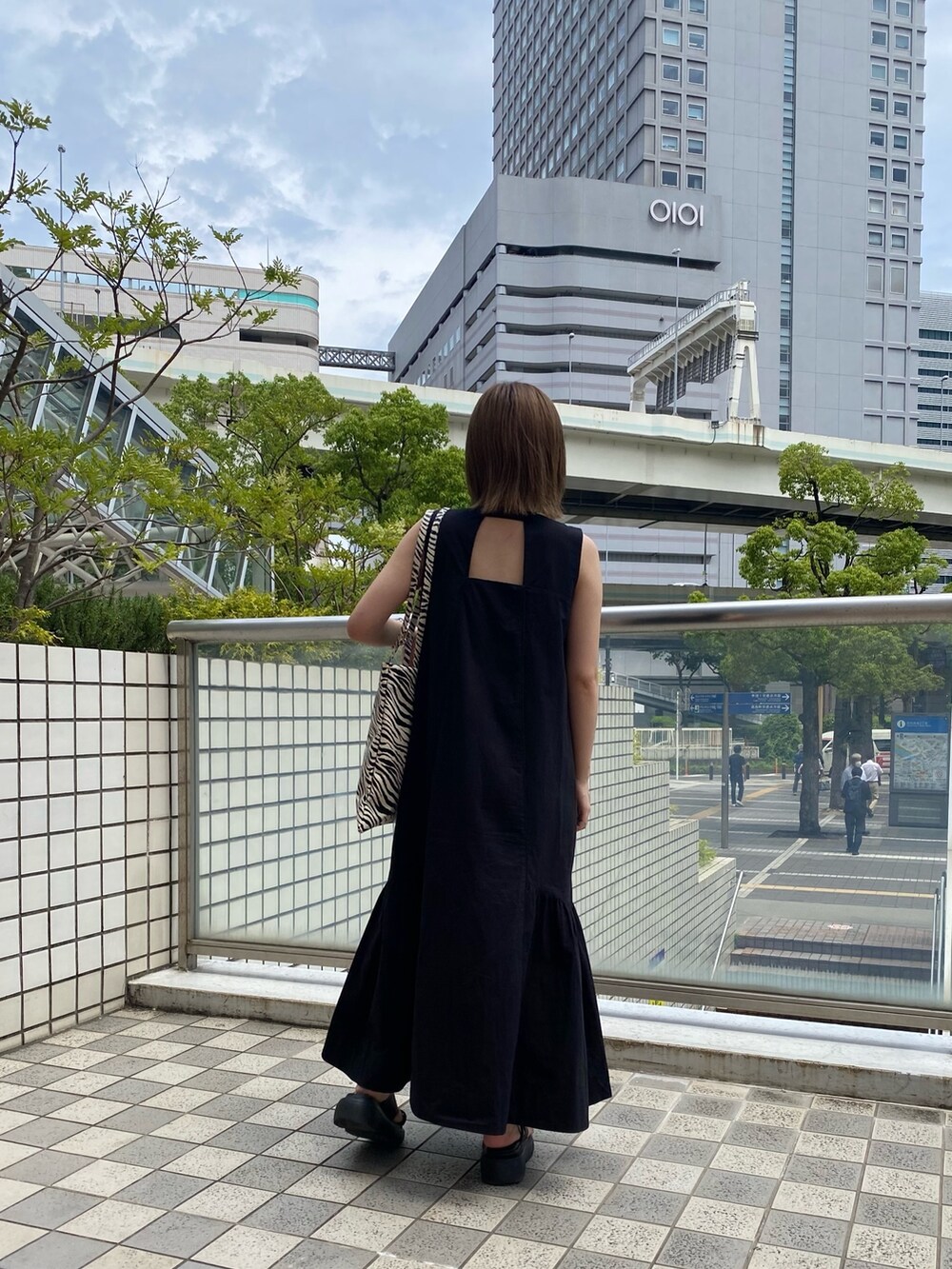 ブラック系のワンピース、その他のトートバッグ、ブラック系のサンダルを着用したレディースの夏コーディネートの2枚目の写真