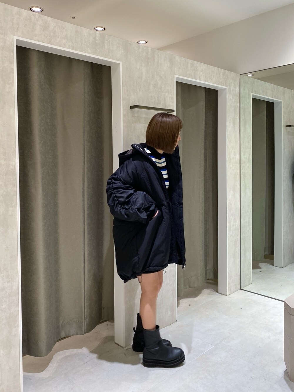 ブラック系のブルゾン、ブルー系のニット/セーター、ブラック系のスカートを着用したレディースの秋コーディネートの3枚目の写真