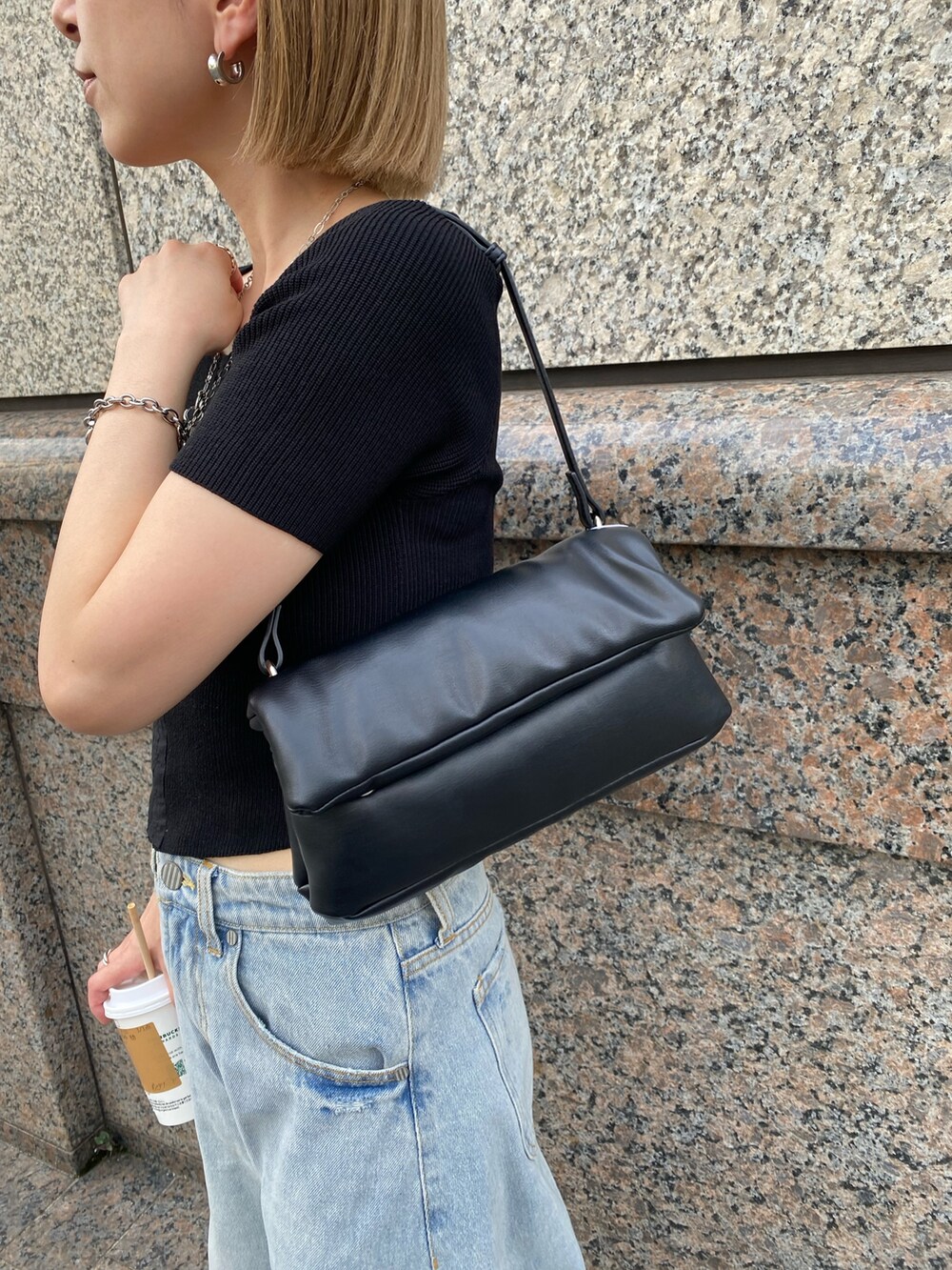 ブルー系のデニムパンツ、ブラック系のニット/セーター、ブラック系のハンドバッグを着用したレディースの夏コーディネートの6枚目の写真