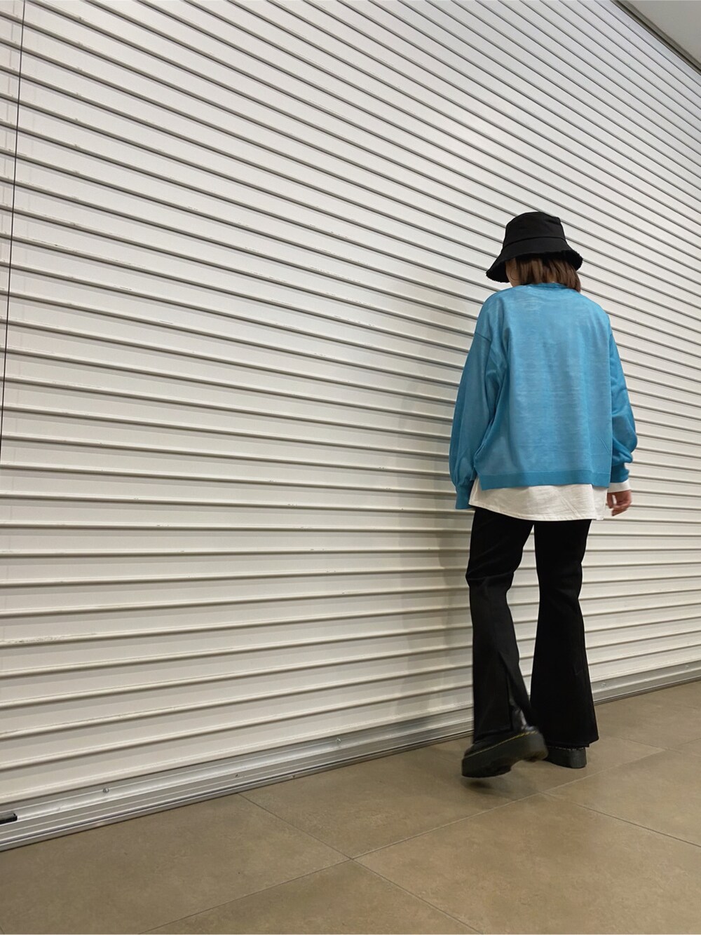 ブラック系のその他パンツ、ブルー系のニット/セーター、ブラック系のハットを着用したレディースの春コーディネートの2枚目の写真