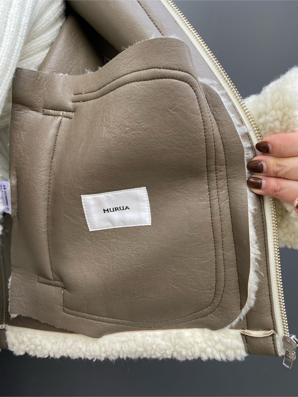 ベージュ系のスカート、ホワイト系のブルゾン、ブラウン系のブーツを着用したレディースの冬コーディネートの5枚目の写真