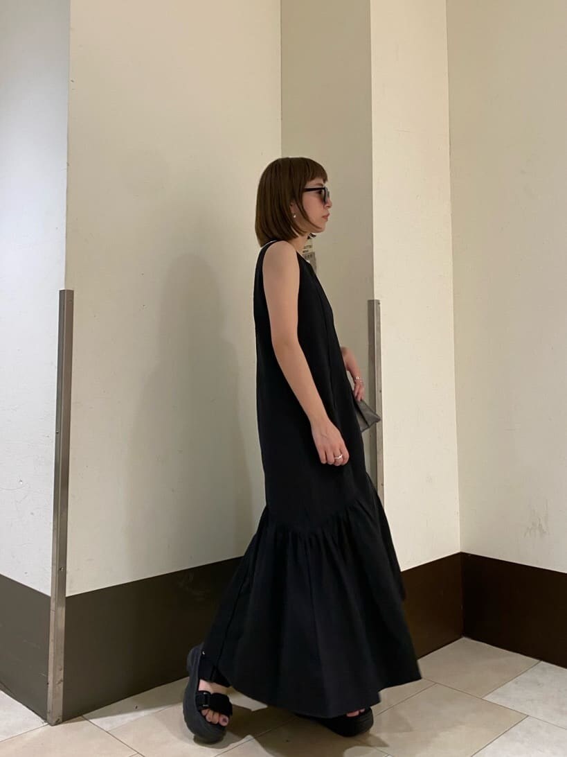 ホワイト系のサンダル、ブラック系のショルダーバッグ、ブラック系のワンピースを着用したレディースの夏コーディネートの4枚目の写真