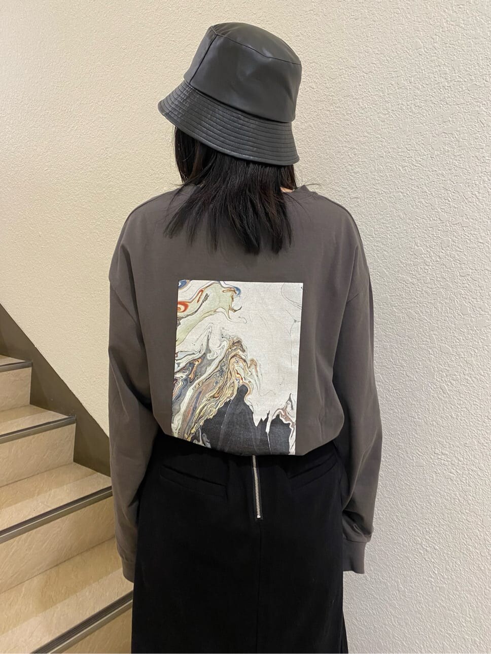 ブラック系のスカート、ブラック系のサンダル、グレー系のTシャツ/カットソーを着用したレディースの春コーディネートの4枚目の写真