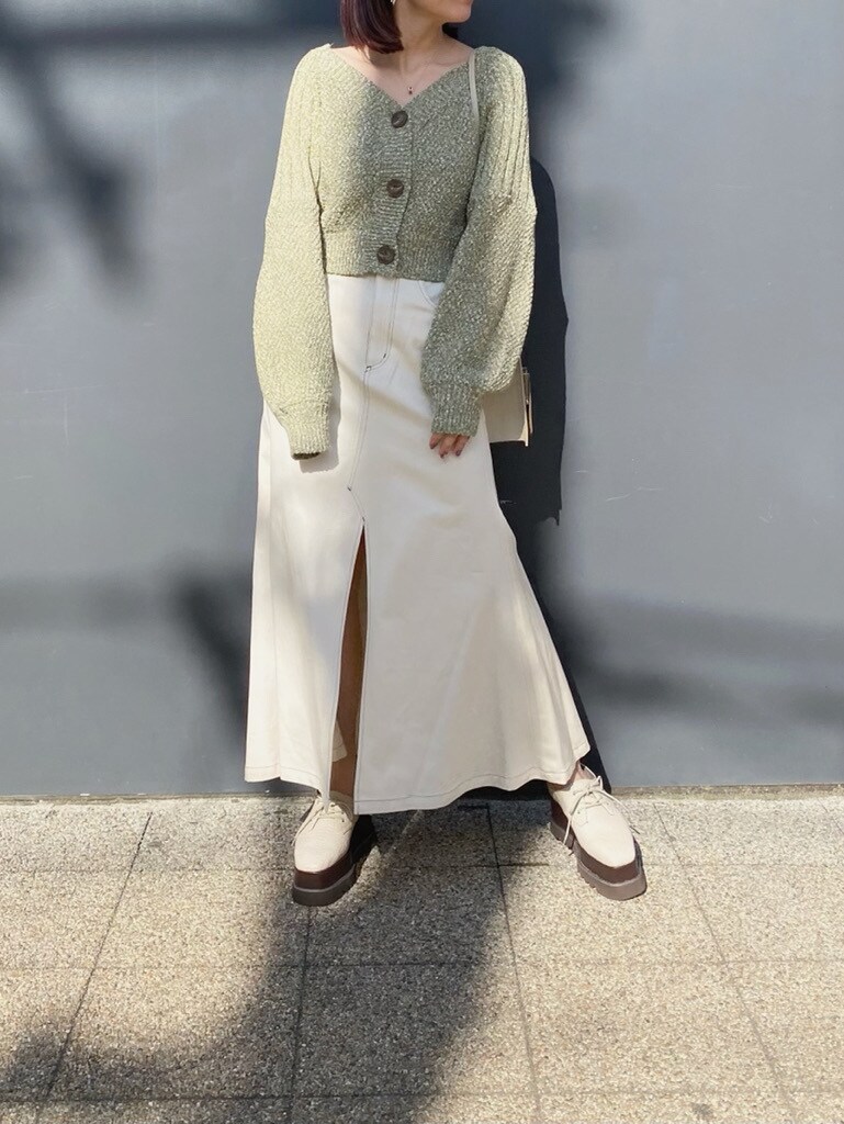 ホワイト系のローファー、ホワイト系のスカート、グリーン系のカーディガン/ボレロを着用したレディースの冬コーディネートの2枚目の写真