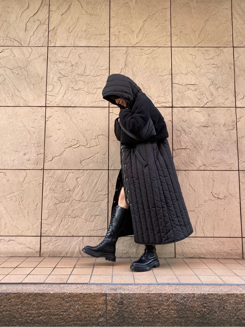 ブラック系のワンピース、ブラック系のダウンジャケット/コート、ブラック系のブーツを着用したレディースの冬コーディネートの5枚目の写真