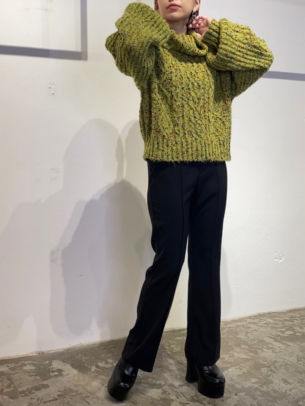 グリーン系のニット/セーター、ブラック系のスウェットパンツ、ブラック系のブーツを着用したレディースの冬コーディネートの2枚目の写真