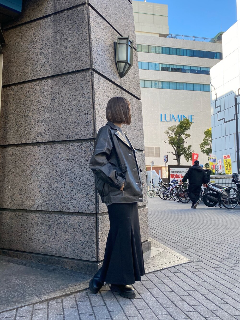 グレー系のブルゾン、グレー系のニット/セーター、ブラック系のスカートを着用したレディースの冬コーディネートの2枚目の写真