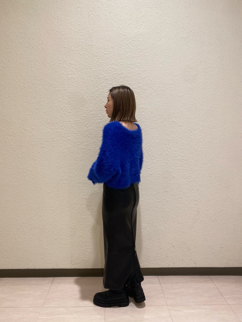 ブルー系のニット/セーター、ブラック系のスカートを着用したレディースの秋コーディネートの2枚目の写真