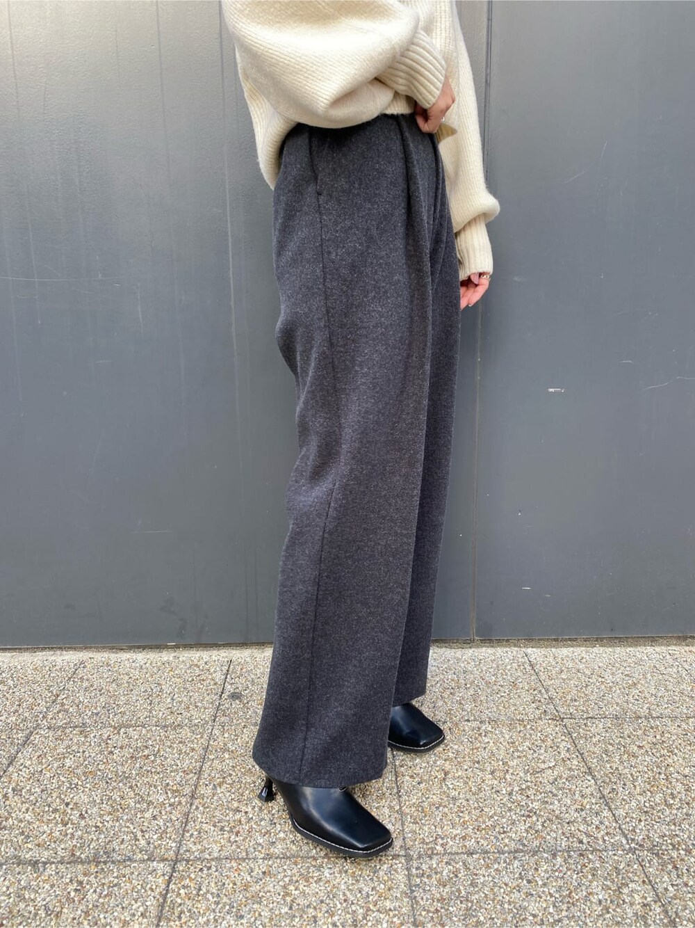 ブラック系のハンドバッグ、グレー系のその他パンツ、ブラック系のブーツを着用したレディースの秋コーディネートの8枚目の写真