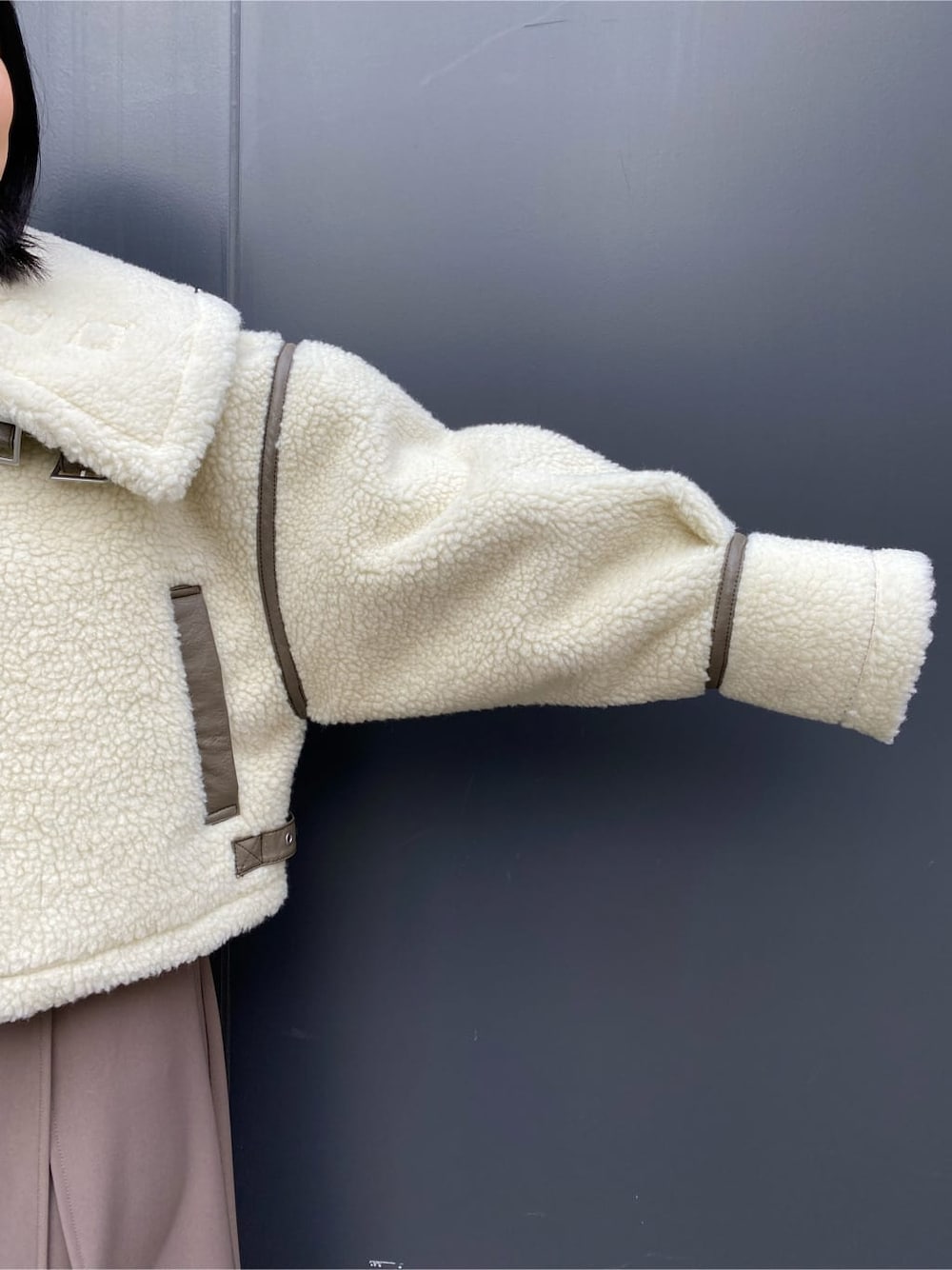 ベージュ系のスカート、ホワイト系のブルゾン、ブラウン系のブーツを着用したレディースの冬コーディネートの4枚目の写真