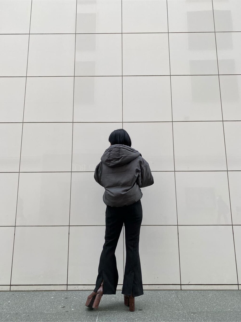 ブラック系のその他パンツ、グレー系のダウンジャケット/コート、ブラック系のニット/セーターを着用したレディースの秋コーディネートの2枚目の写真