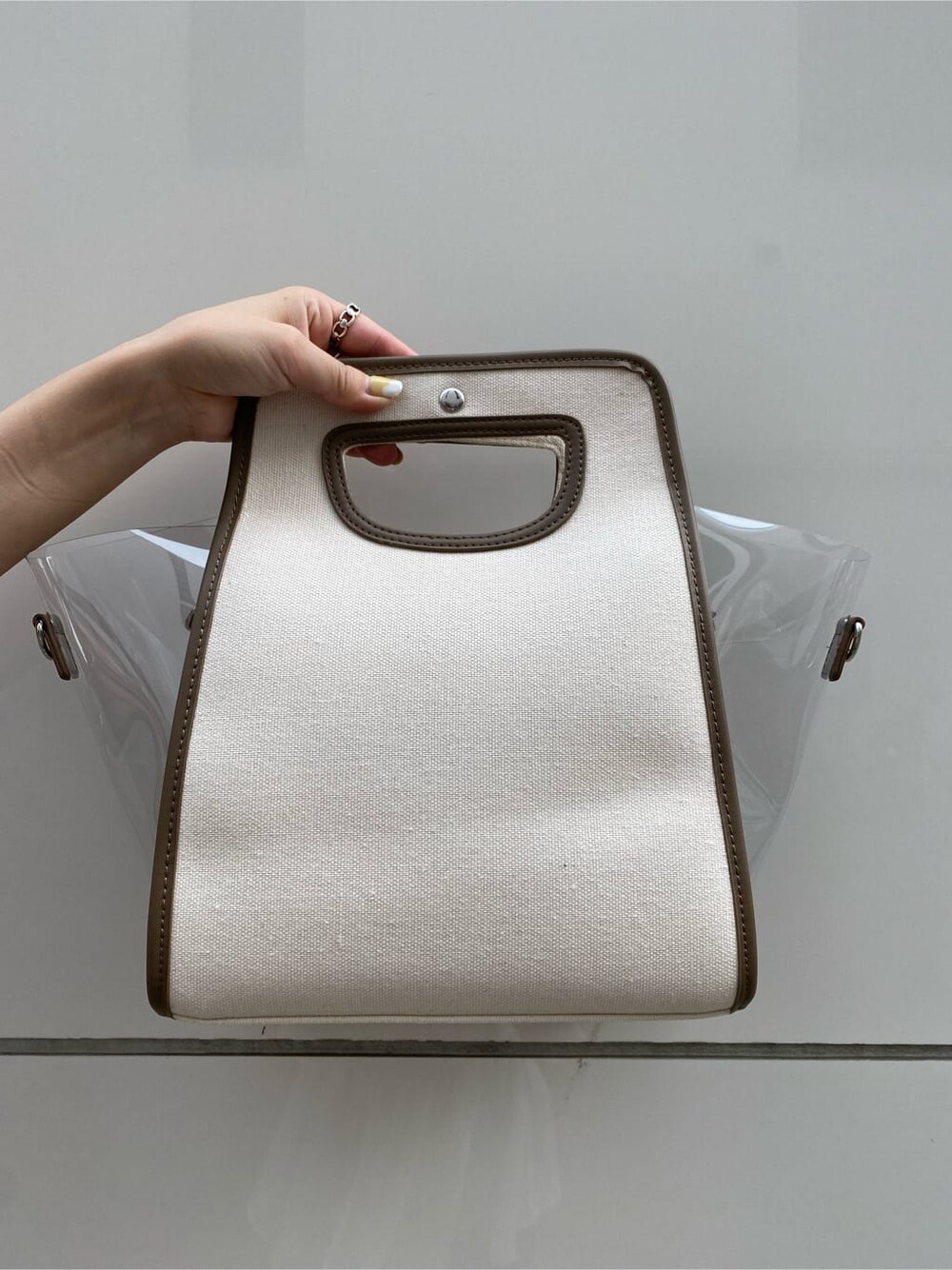 ホワイト系のサンダル、ベージュ系のワンピース、ブラウン系のハンドバッグを着用したレディースの夏コーディネートの4枚目の写真