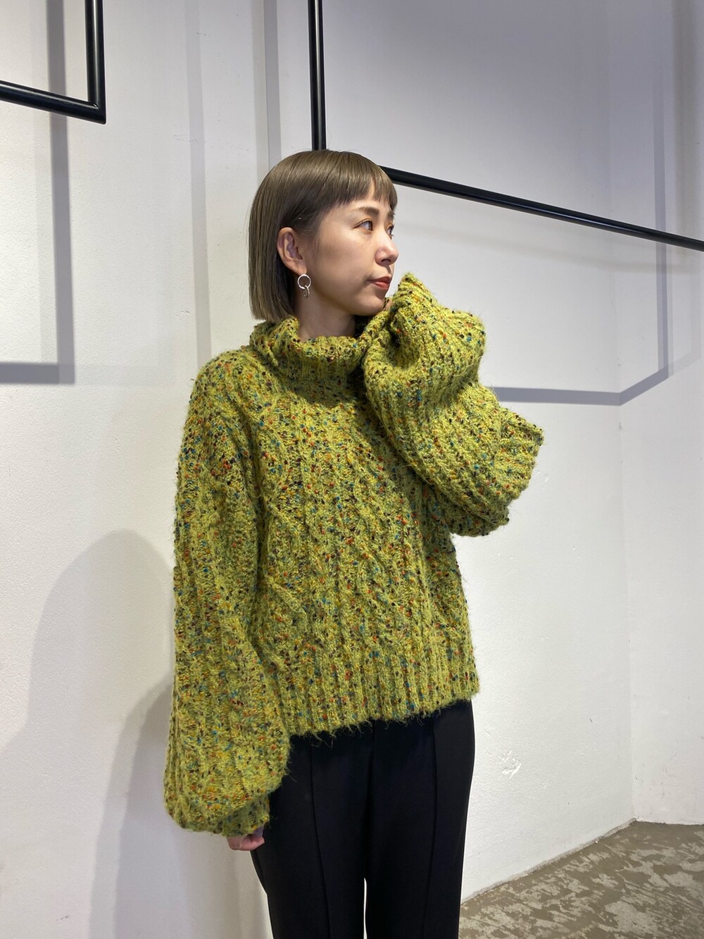 グリーン系のニット/セーター、ブラック系のスウェットパンツ、ブラック系のブーツを着用したレディースの冬コーディネートの6枚目の写真