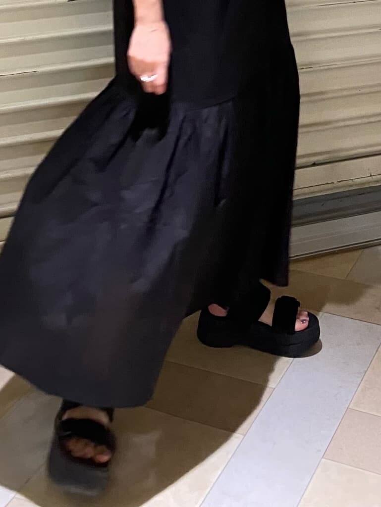 ブラック系のサンダル、ブラック系のショルダーバッグ、ブラウン系のワンピースを着用したレディースの夏コーディネートの6枚目の写真