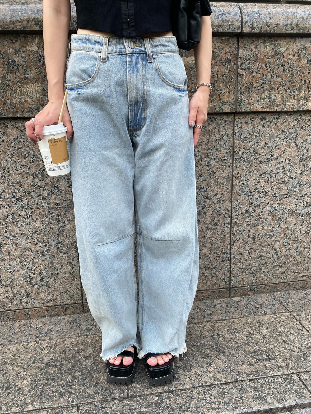 ブルー系のデニムパンツ、ブラック系のニット/セーター、ブラック系のハンドバッグを着用したレディースの夏コーディネートの5枚目の写真