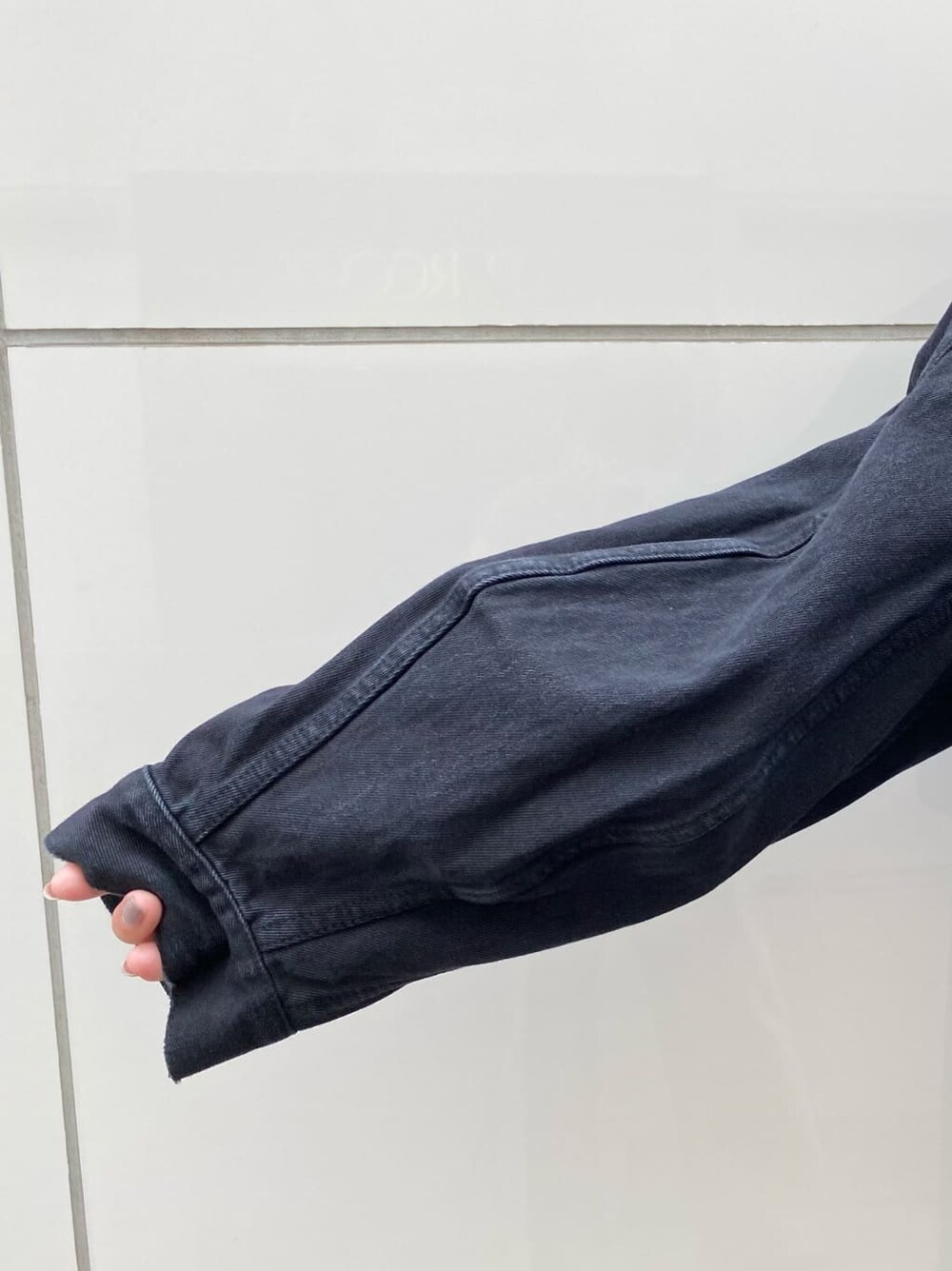 ブラック系のスカート、ブラック系のパンプス、ブラック系のブルゾンを着用したレディースの夏コーディネートの6枚目の写真