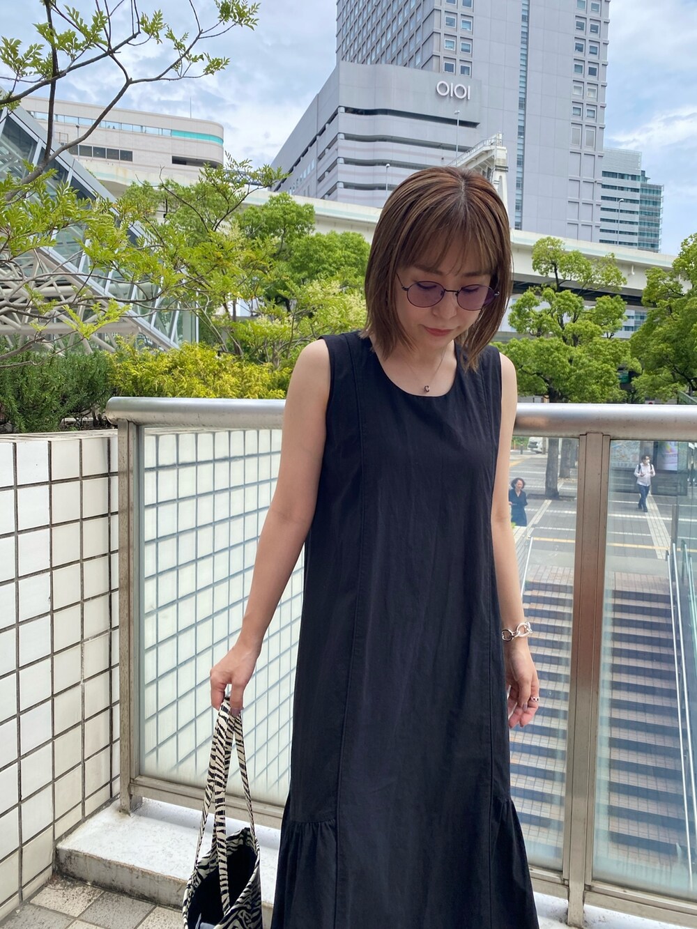 ブラック系のワンピース、その他のトートバッグ、ブラック系のサンダルを着用したレディースの夏コーディネートの5枚目の写真