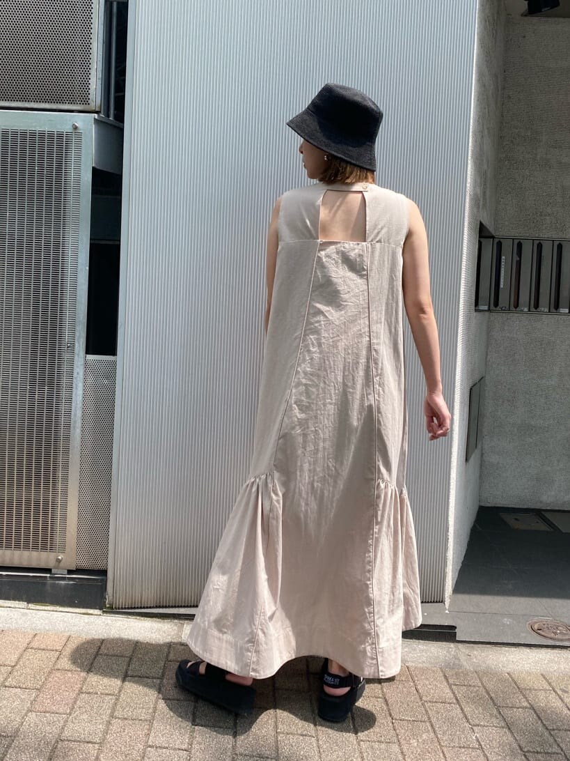 ベージュ系のワンピース、ブラック系のハットを着用したレディースの夏コーディネートの3枚目の写真