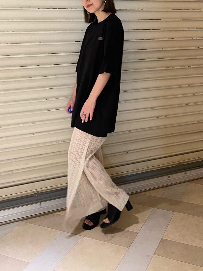 ブラック系のサンダル、ブラック系のTシャツ/カットソー、ホワイト系のスウェットパンツを着用したレディースの春コーディネートの7枚目の写真