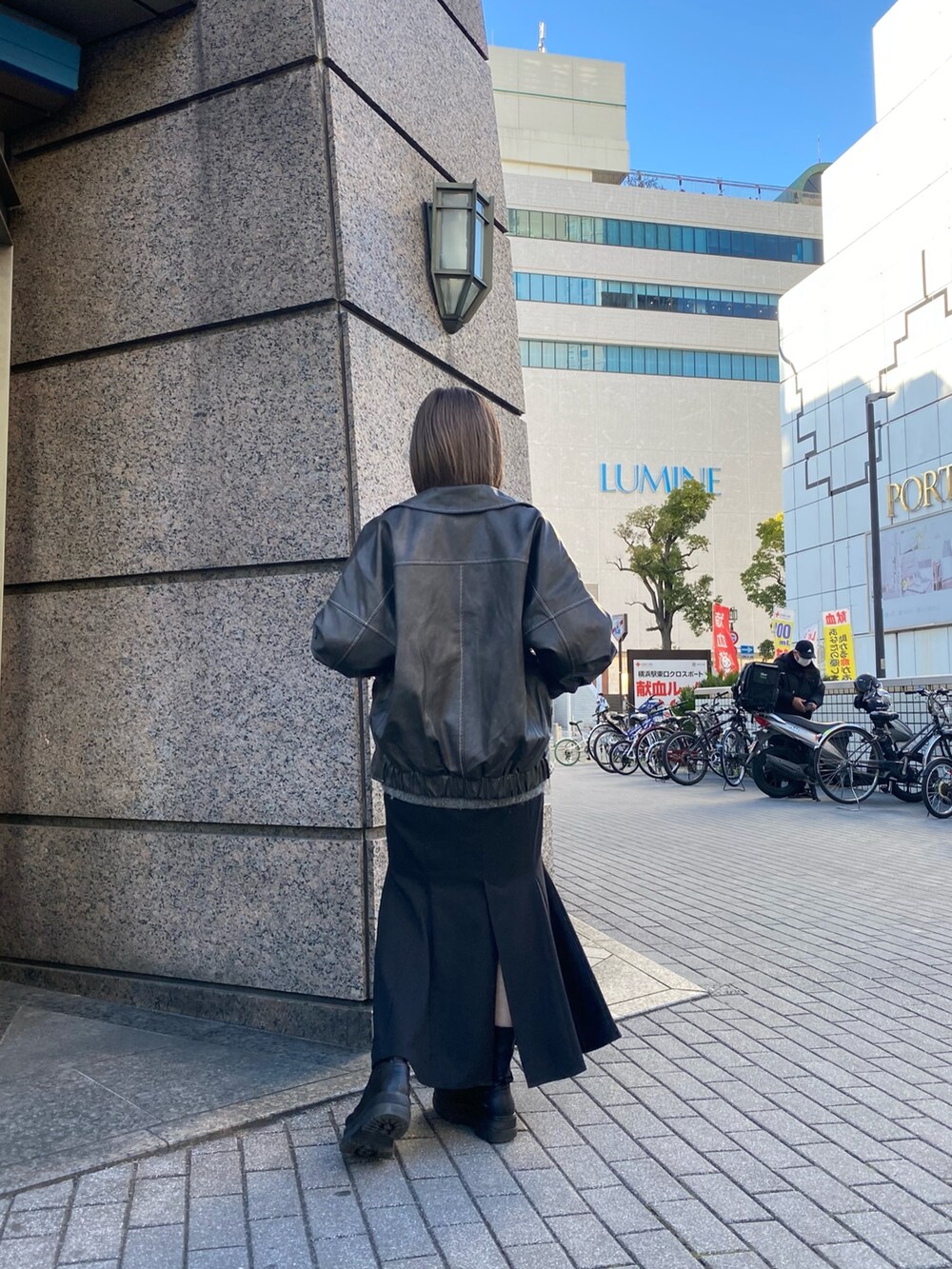 グレー系のブルゾン、グレー系のニット/セーター、ブラック系のスカートを着用したレディースの冬コーディネートの3枚目の写真