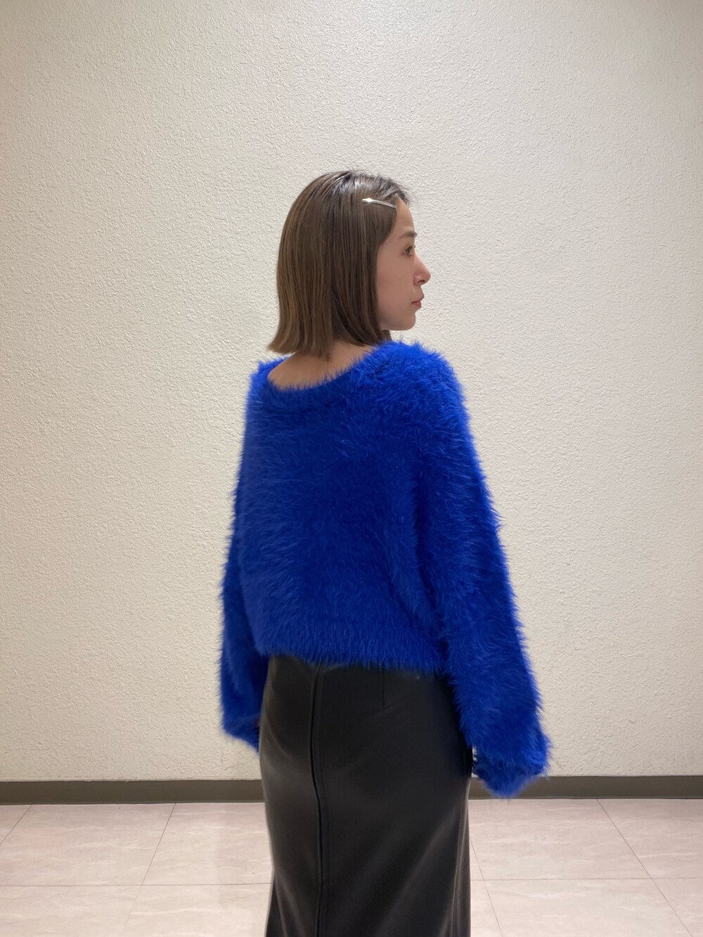 ブルー系のニット/セーター、ブラック系のスカートを着用したレディースの秋コーディネートの5枚目の写真