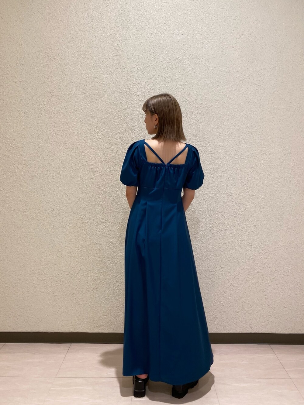 ブルー系のワンピース、ブラック系のサンダル、ブラック系のハンドバッグを着用したレディースの夏コーディネートの2枚目の写真