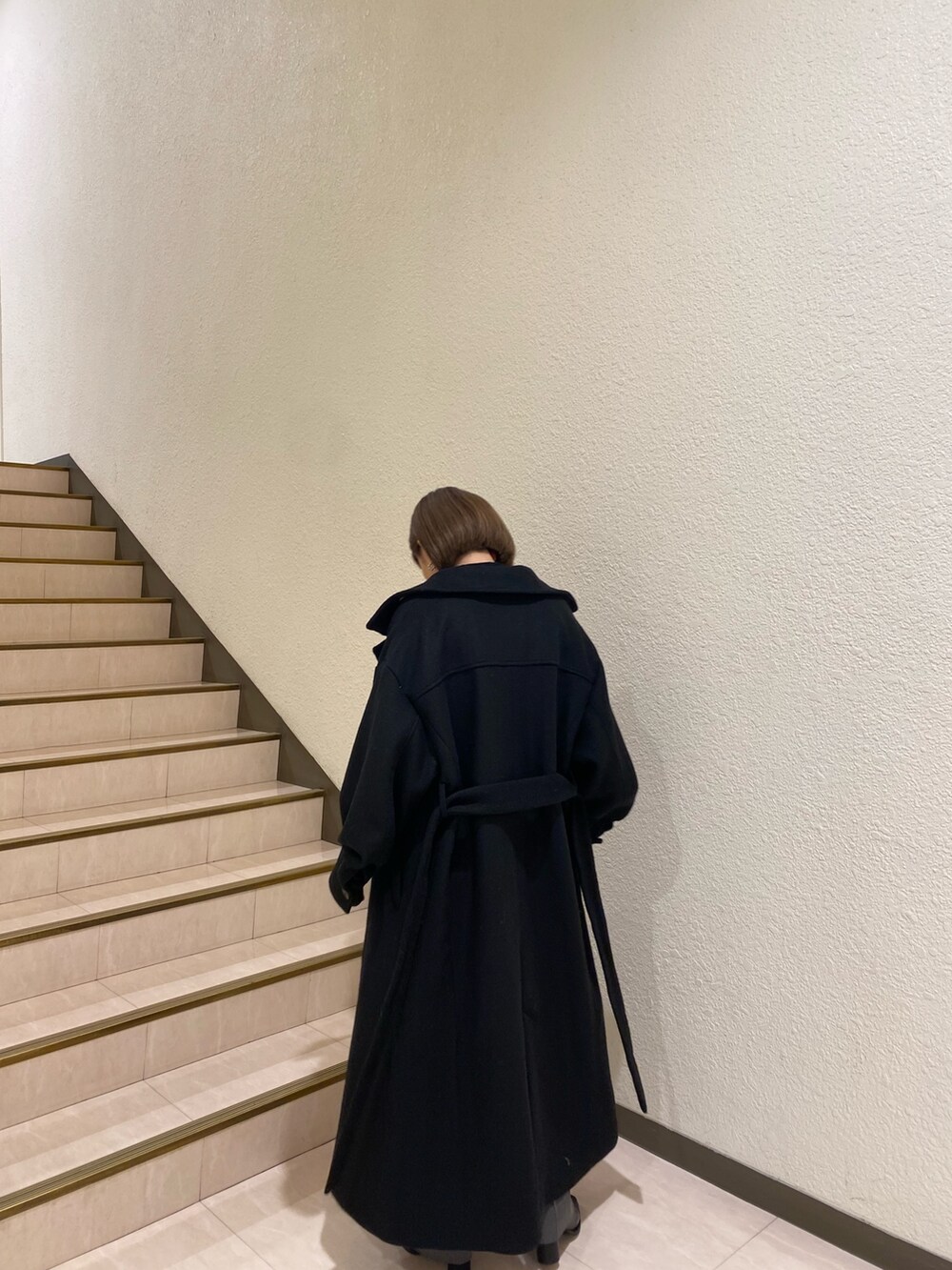 ブラック系のダウンジャケット/コート、パープル系のニット/セーター、グレー系のスラックスを着用したレディースの秋コーディネートの6枚目の写真