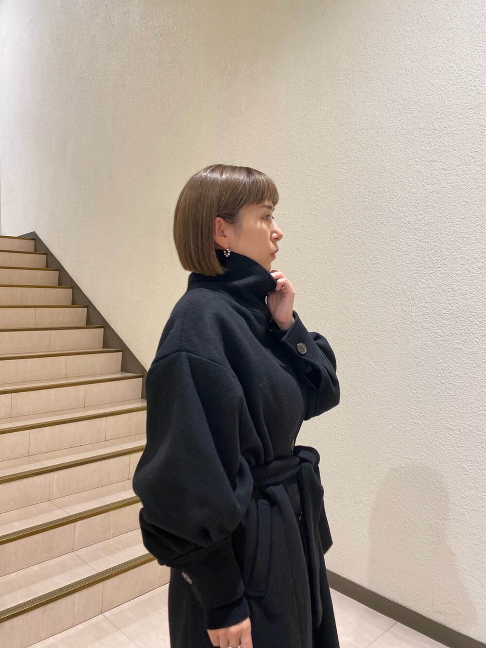 ブラック系のダウンジャケット/コート、パープル系のニット/セーター、グレー系のスラックスを着用したレディースの秋コーディネートの10枚目の写真