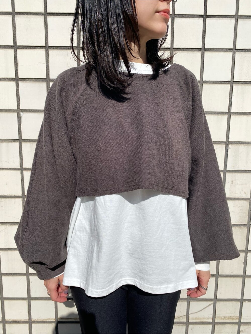 ブラック系のハンドバッグ、ブラック系のスラックス、ブラック系のブーツを着用したレディースの冬コーディネートの4枚目の写真