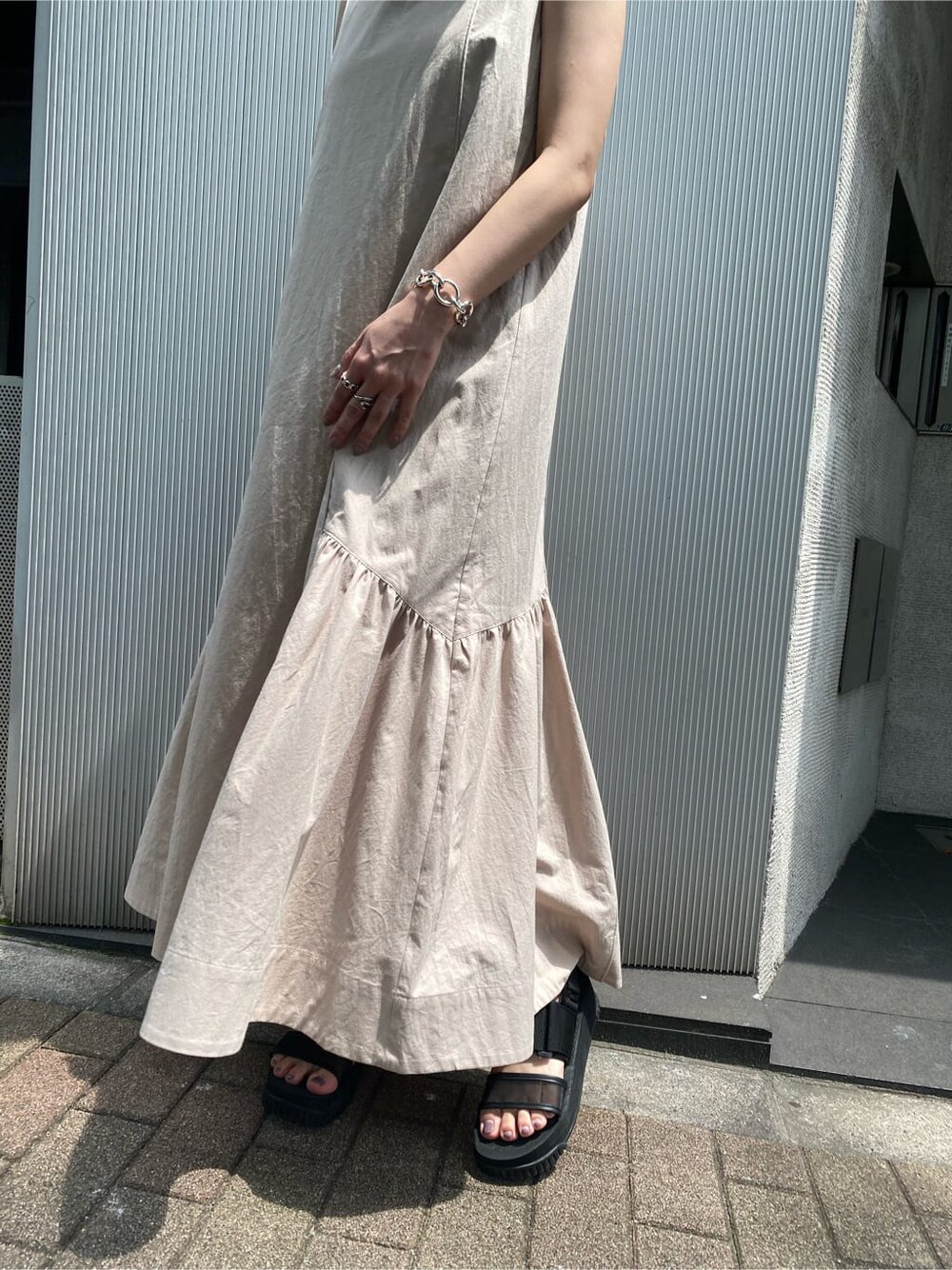 ベージュ系のワンピース、ブラック系のハットを着用したレディースの夏コーディネートの6枚目の写真