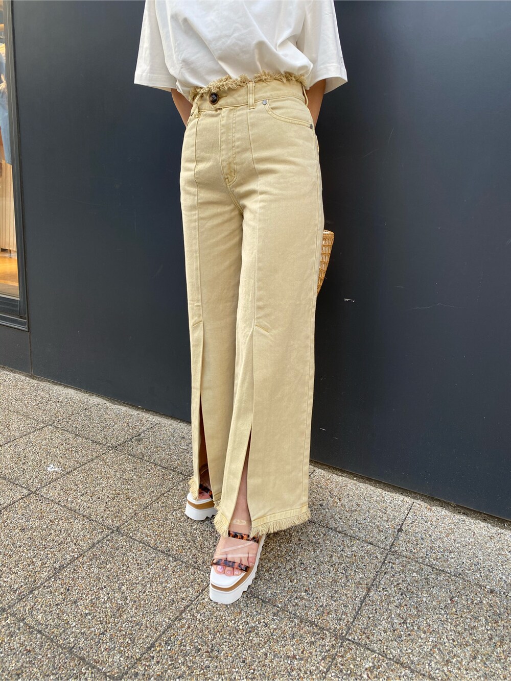 ベージュ系のかごバッグ、イエロー系のその他パンツ、ホワイト系のTシャツ/カットソーを着用したレディースの春コーディネートの5枚目の写真