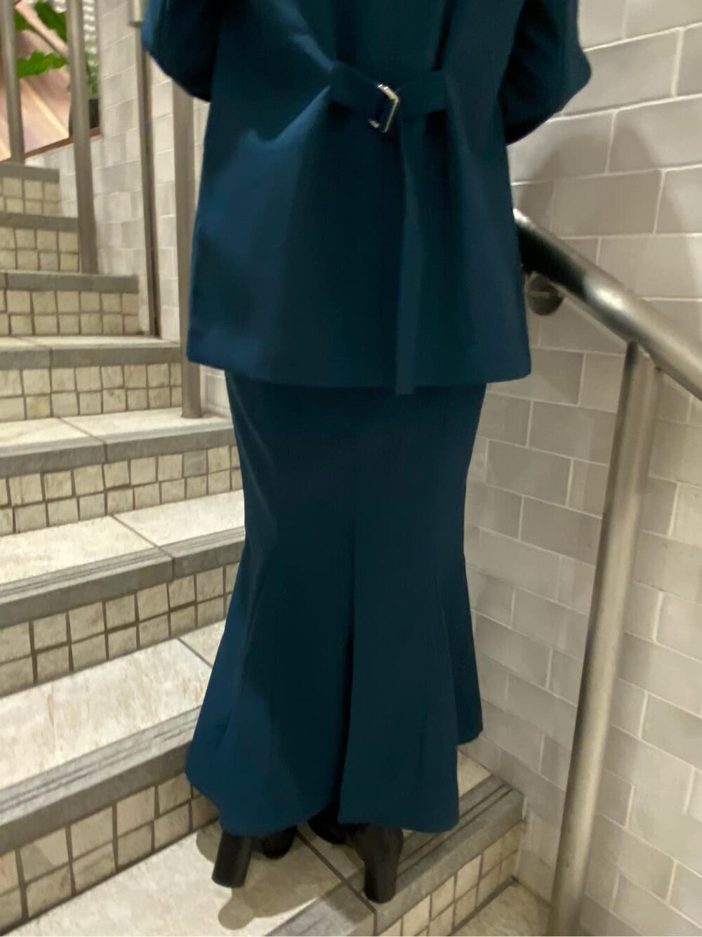 ブラック系のタンクトップ、グリーン系のテーラードジャケット、グリーン系のスカートを着用したレディースの夏コーディネートの8枚目の写真