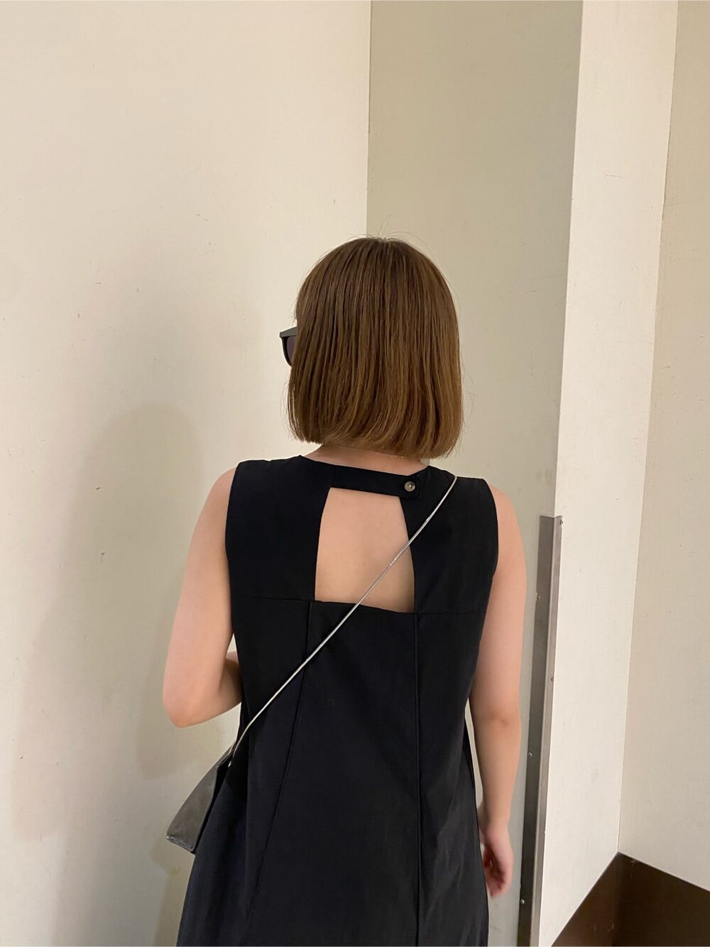 ホワイト系のサンダル、ブラック系のショルダーバッグ、ブラック系のワンピースを着用したレディースの夏コーディネートの7枚目の写真