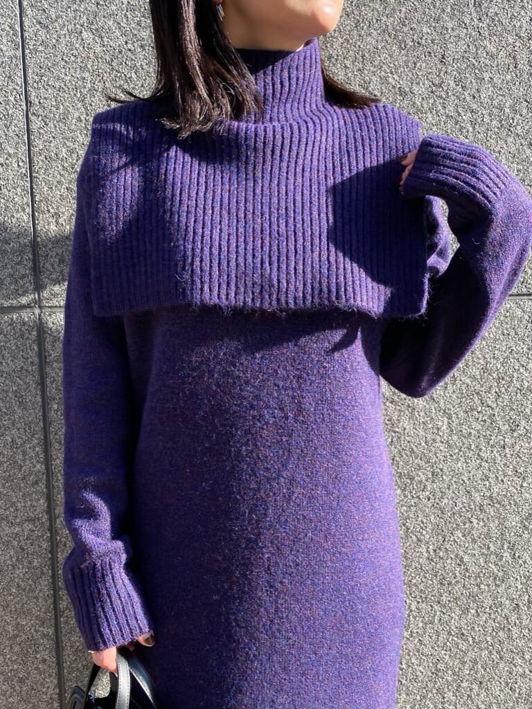 ブラック系のハンドバッグ、パープル系のワンピース、ブラック系のブーツを着用したレディースの冬コーディネートの3枚目の写真