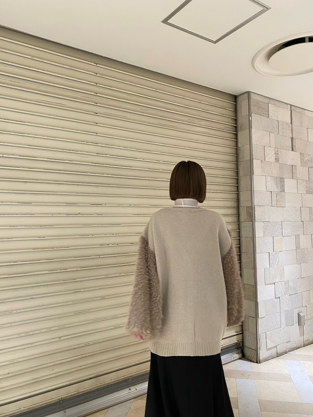 ベージュ系のカーディガン/ボレロ、その他のスカート、ブラック系のブーツを着用したレディースの秋コーディネートの7枚目の写真