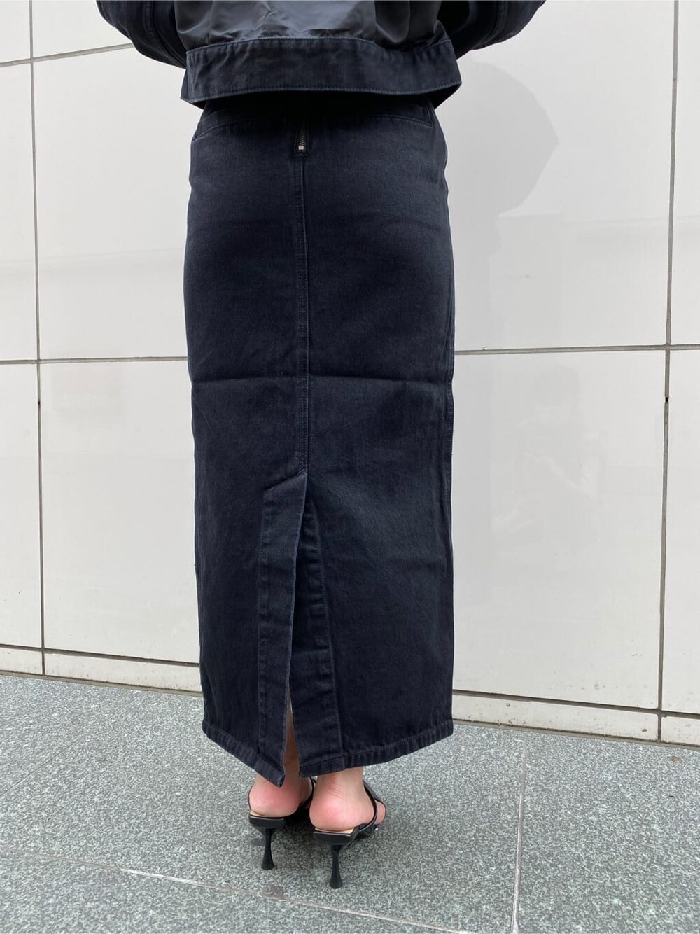 ブラック系のスカート、ブラック系のパンプス、ブラック系のブルゾンを着用したレディースの夏コーディネートの8枚目の写真