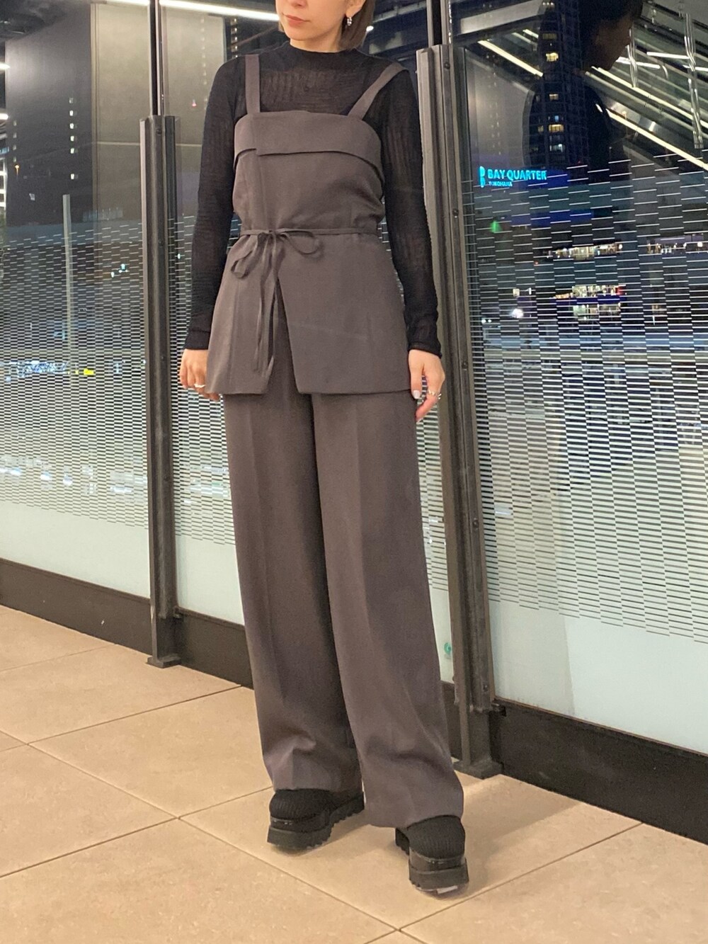 グレー系のシャツ/ブラウス、ブラック系のニット/セーター、グレー系のその他パンツを着用したレディースの冬コーディネートの2枚目の写真