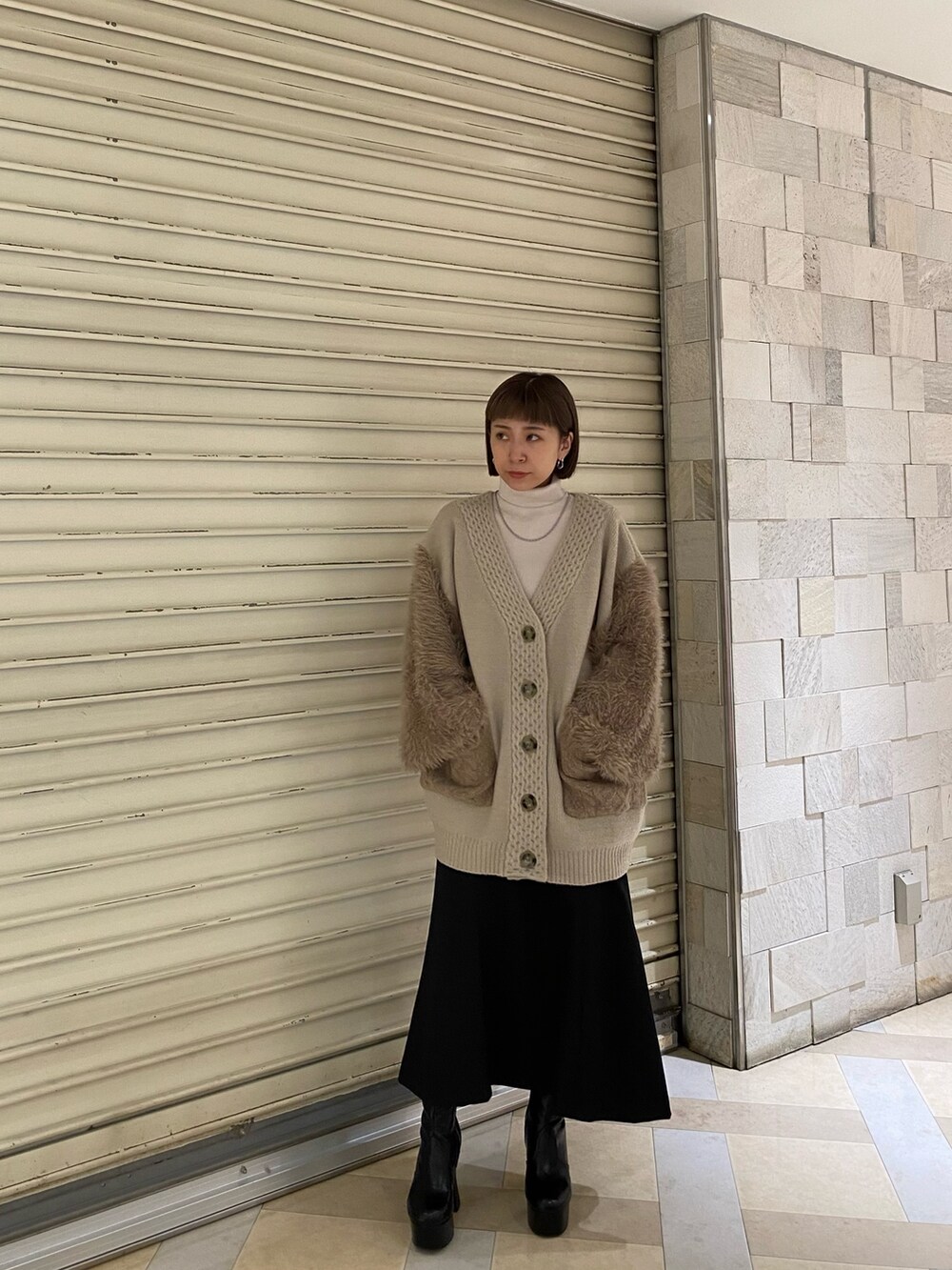 ベージュ系のカーディガン/ボレロ、その他のスカート、ブラック系のブーツを着用したレディースの秋コーディネートの2枚目の写真