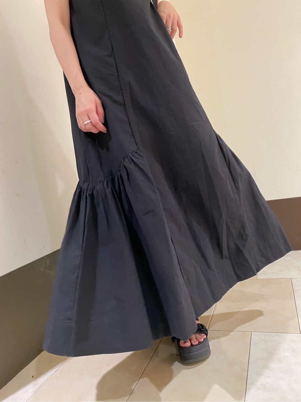 ホワイト系のサンダル、ブラック系のショルダーバッグ、ブラック系のワンピースを着用したレディースの夏コーディネートの10枚目の写真