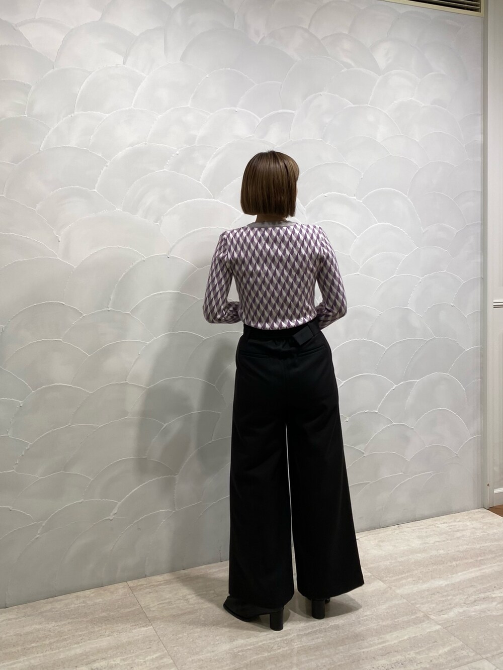 ブラック系のニット/セーター、ブラック系のスラックス、ブラック系のブーツを着用したレディースの冬コーディネートの3枚目の写真