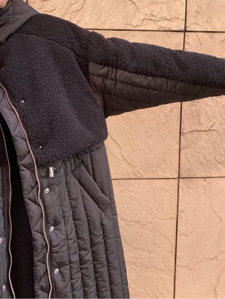 ブラック系のワンピース、ブラック系のダウンジャケット/コート、ブラック系のブーツを着用したレディースの冬コーディネートの7枚目の写真